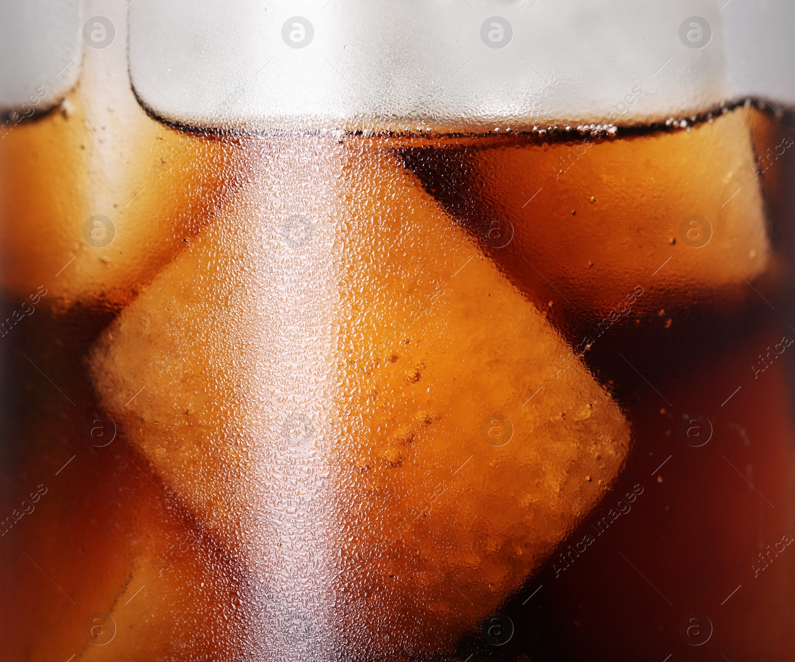 Photo of Glass of refreshing drink with ice cubes on light grey background, closeup