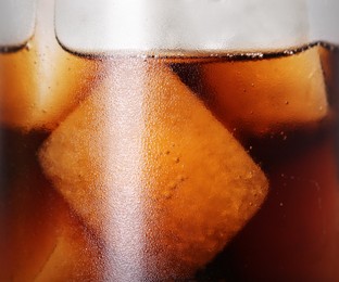 Photo of Glass of refreshing drink with ice cubes on light grey background, closeup