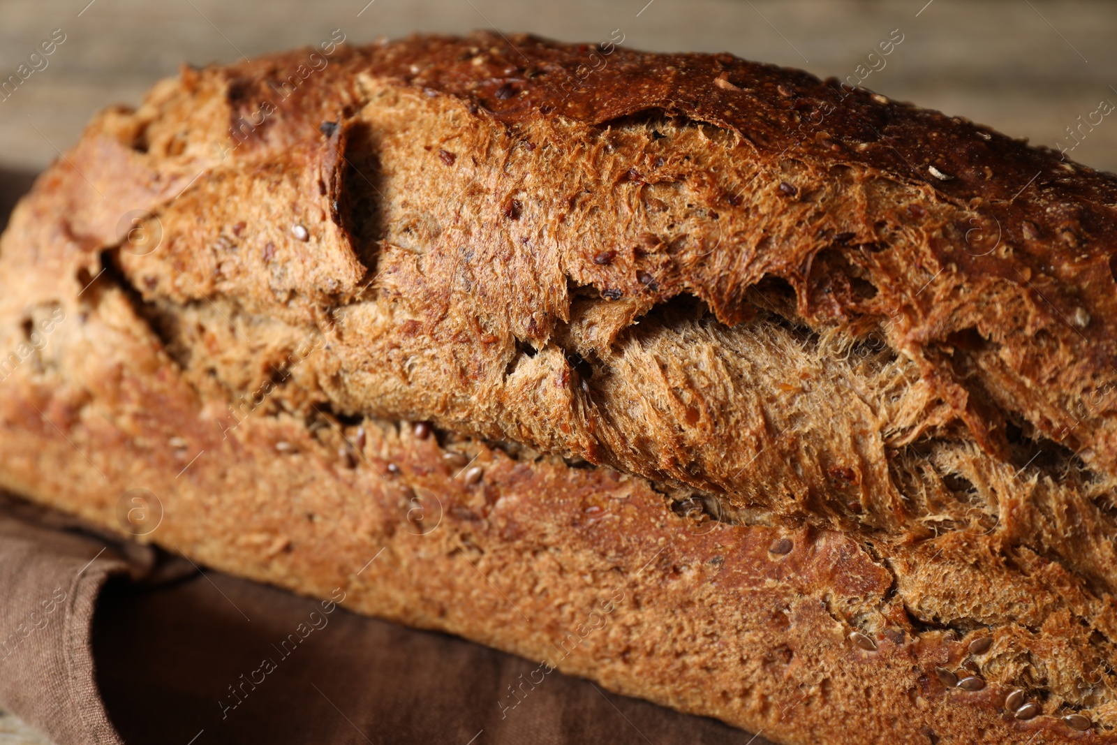 Photo of Freshly baked sourdough bread on wooden table, closeup