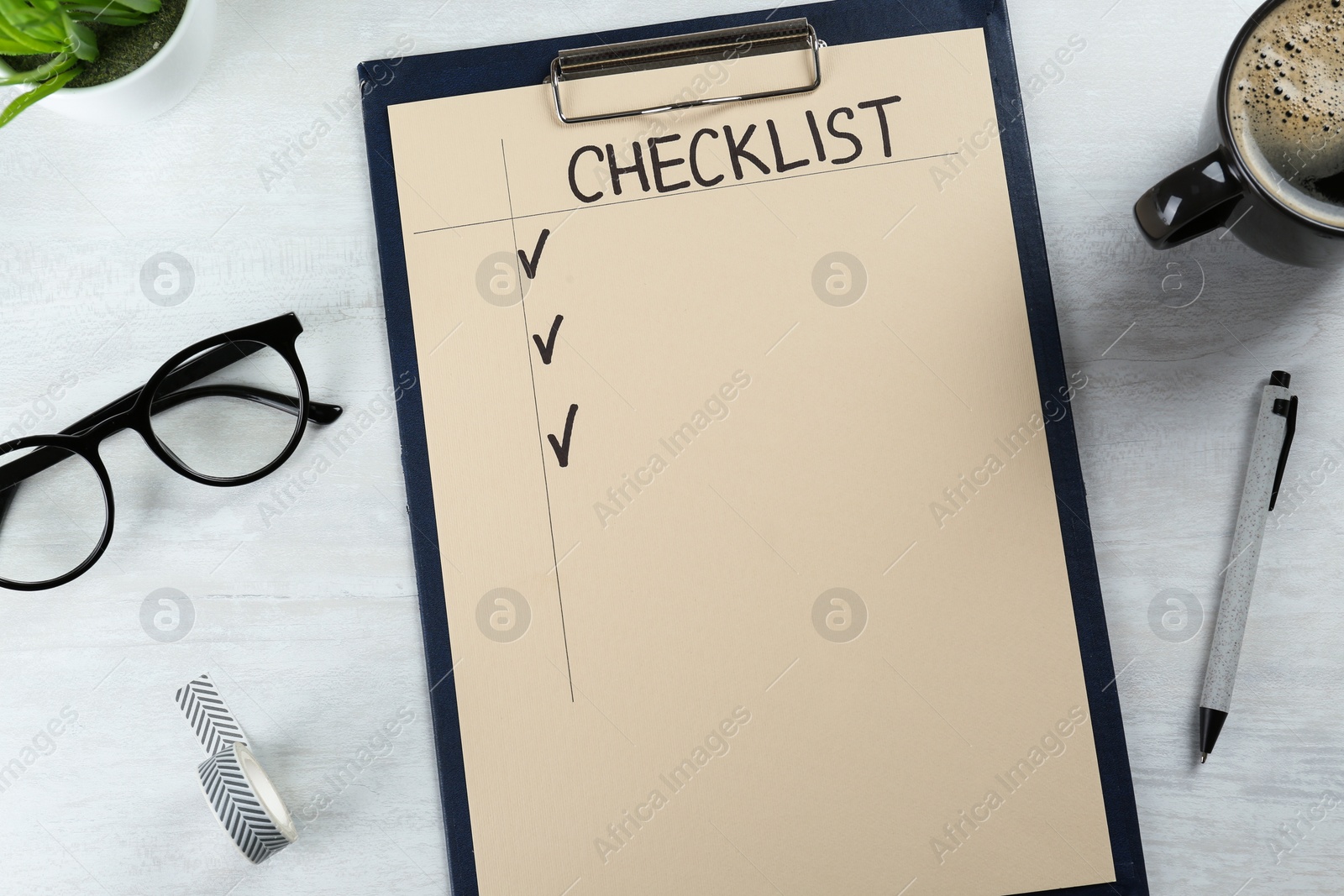 Photo of Clipboard with inscription Checklist, cup of coffee and eyeglasses on white wooden table, flat lay
