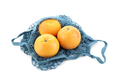 Photo of String bag with oranges isolated on white