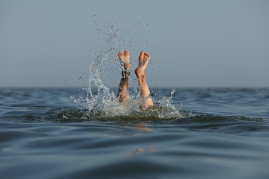 Photo of Drowning woman's legs sticking out of sea