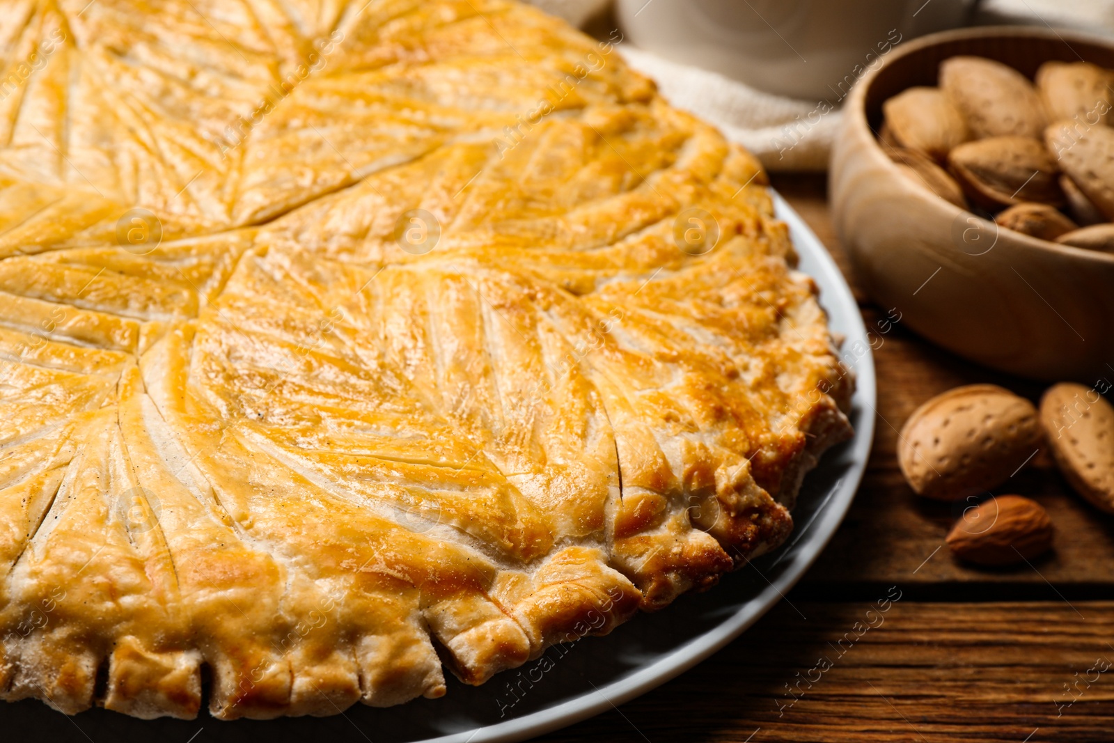 Photo of Traditional galette des rois on wooden table, closeup