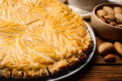 Photo of Traditional galette des rois on wooden table, closeup