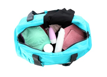 Photo of Sport bag with deodorants and clothes on white background, top view