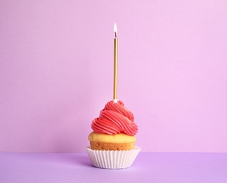 Photo of Birthday cupcake with candle on violet background