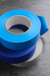 Colorful insulating tapes on dark gray background, closeup