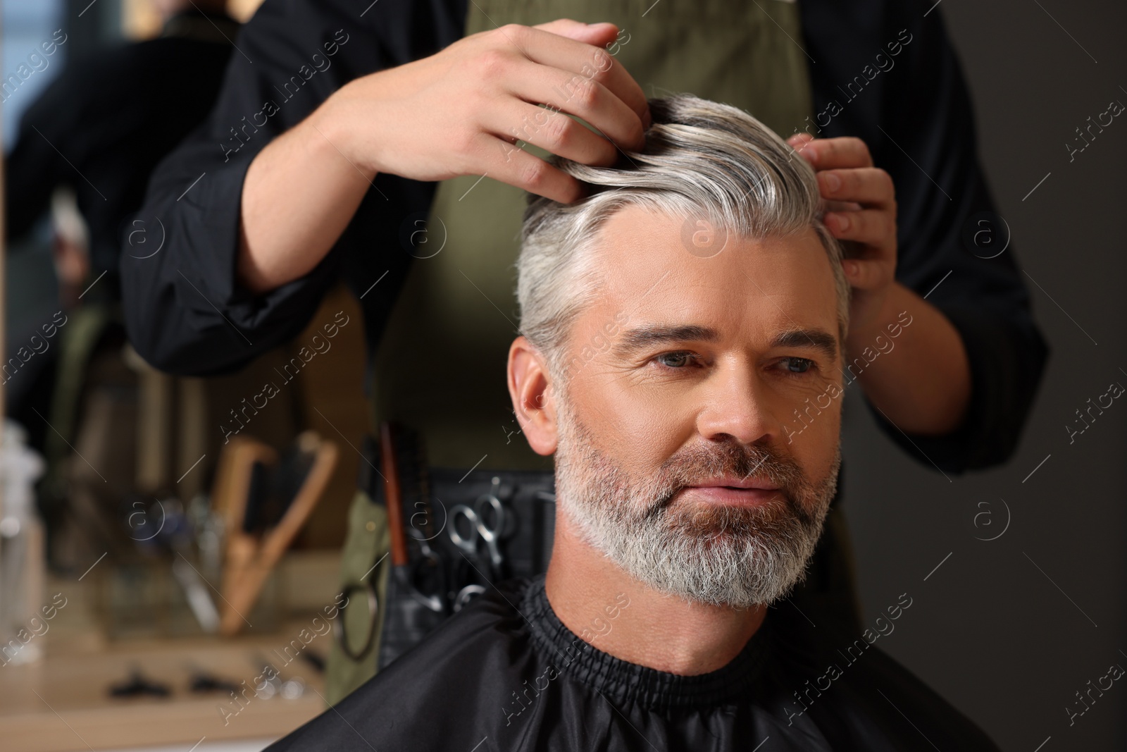 Photo of Hair styling. Professional hairdresser working with client in barbershop, closeup