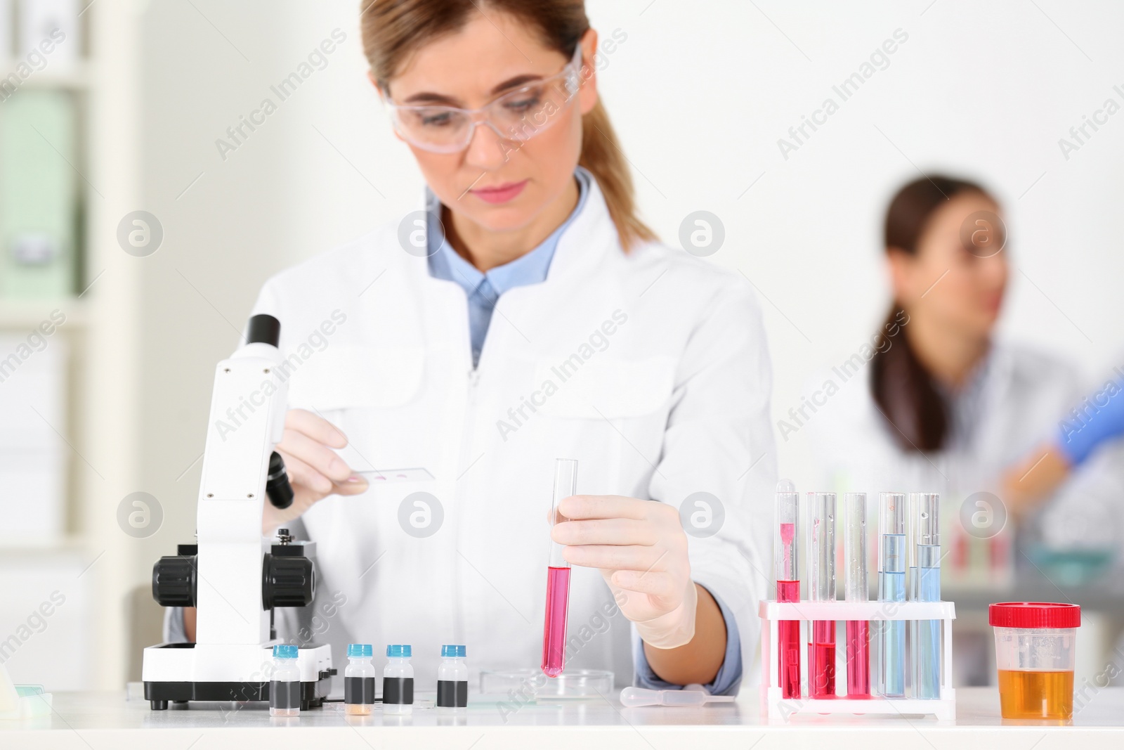 Photo of Female scientist working at table in laboratory. Research and analysis