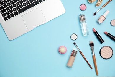 Photo of Flat lay composition with laptop and makeup products for woman on color background