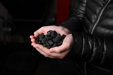 Photo of Woman with handful of coal, closeup view