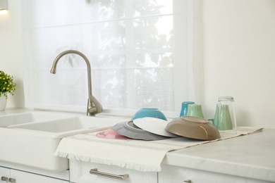 Photo of Clean dishes drying on counter in kitchen