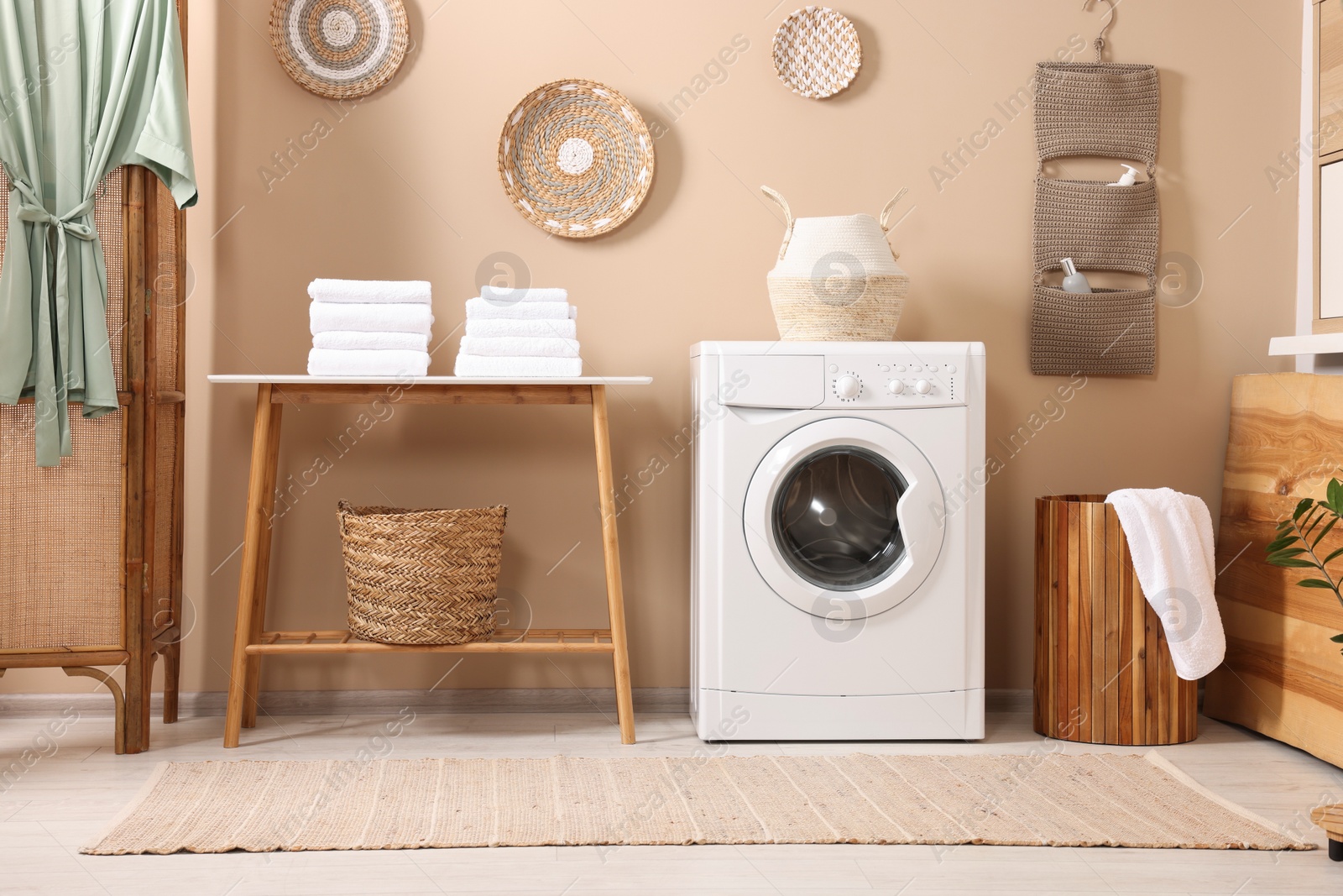 Photo of Stylish laundry room with modern washing machine. Interior design