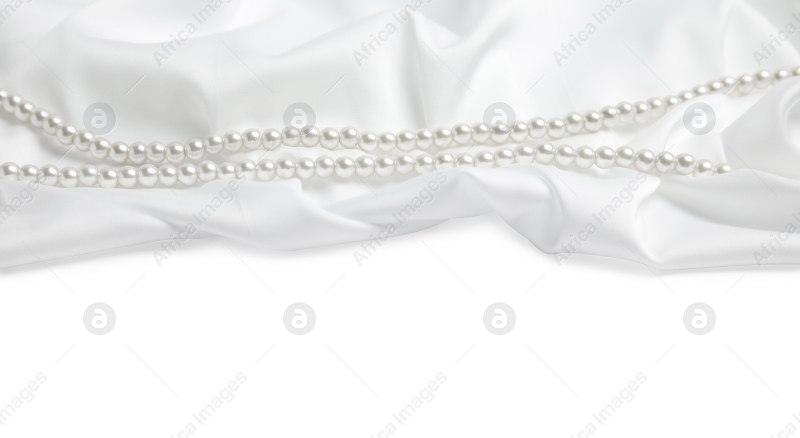 Photo of Beautiful pearls and delicate silk on white background