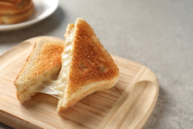 Photo of Wooden board with fresh cheese sandwiches on table