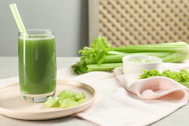 Glass of delicious celery juice and vegetables on grey table, closeup. Space for text