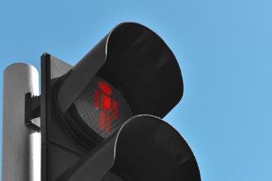 Photo of Traffic light with red signal against blue sky, closeup