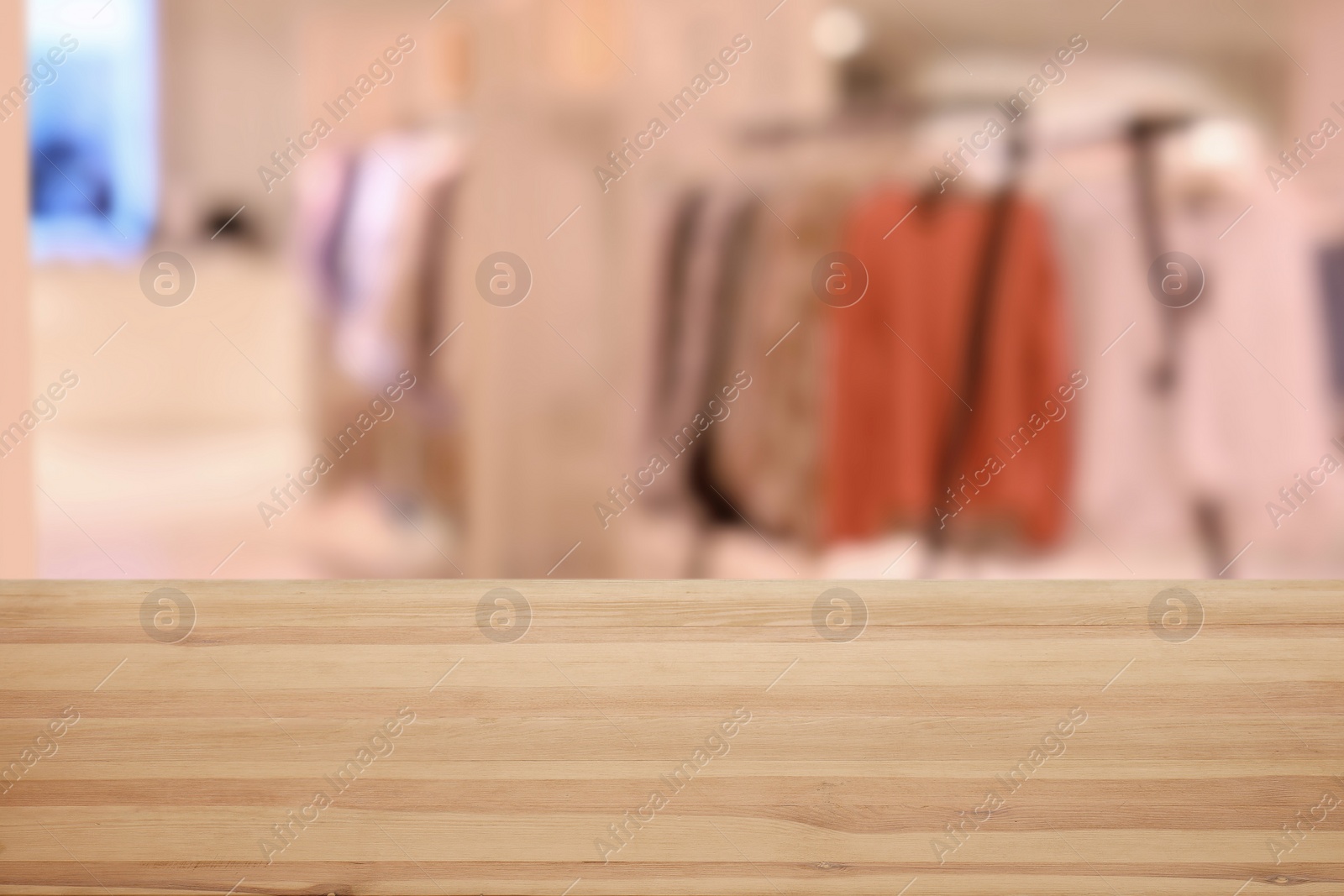 Image of Empty wooden table and blurred view of store with modern clothes