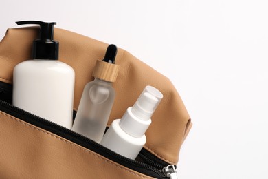 Preparation for spa. Compact toiletry bag with cosmetic products on white background, top view. Space for text