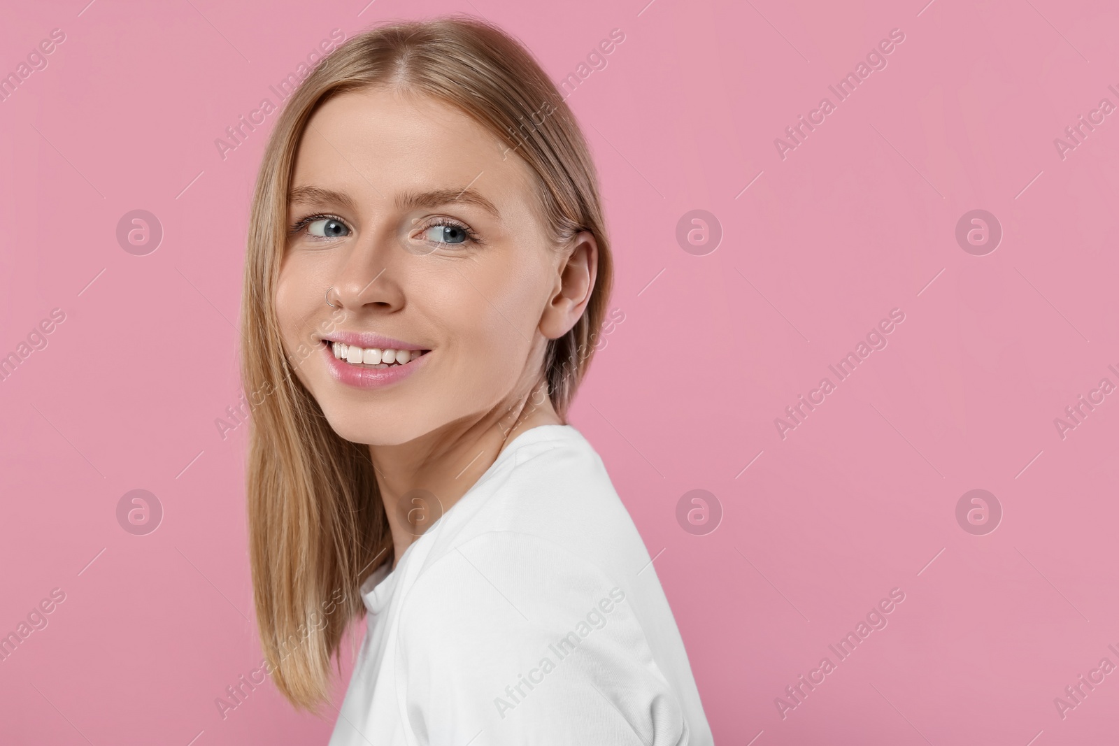 Photo of Portrait of beautiful young woman on pink background. Space for text