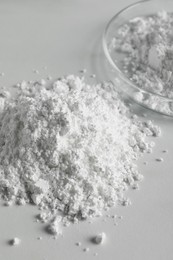 Heap of calcium carbonate powder on white table