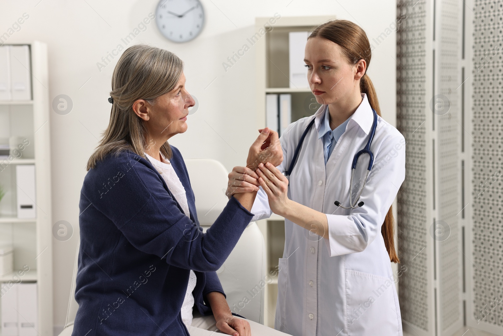 Photo of Arthritis symptoms. Doctor examining patient's hand in hospital