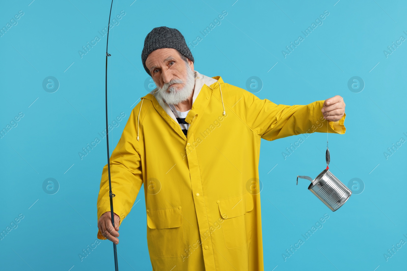 Photo of Fisherman with fishing rod and tin can on light blue background