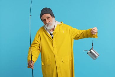 Fisherman with fishing rod and tin can on light blue background