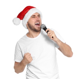 Young man in Santa hat singing into microphone on white background. Christmas music