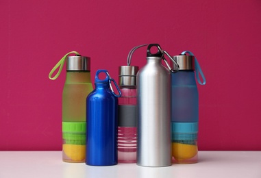 Photo of Different water bottles for sports on color background