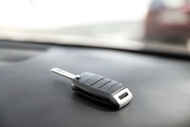 Photo of Car key on dashboard in auto against blurred background
