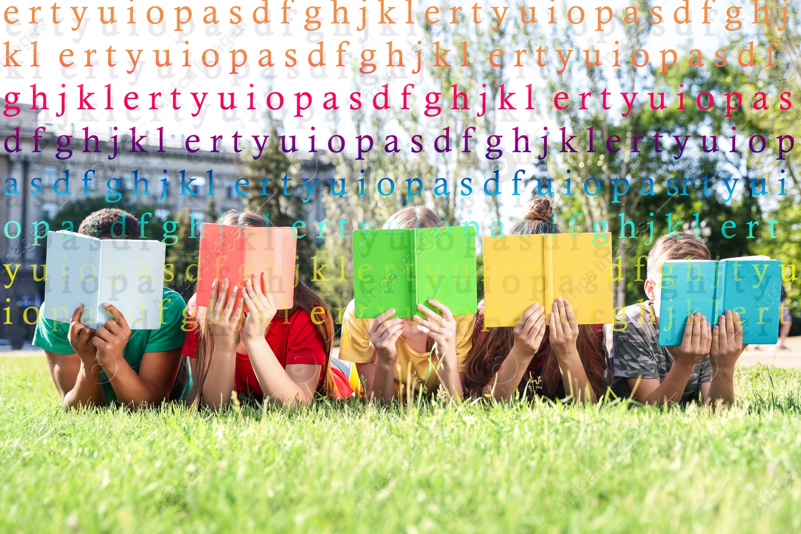 Image of Group of little children reading books on green grass in park