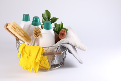 Photo of Set of different cleaning supplies in basket on white background