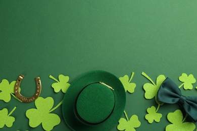 Photo of Leprechaun's hat and St. Patrick's day decor on green background, flat lay. Space for text