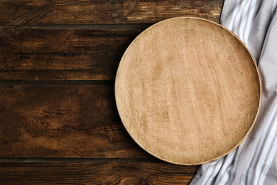 Photo of Empty plate and fabric on wooden table, flat lay. Space for text