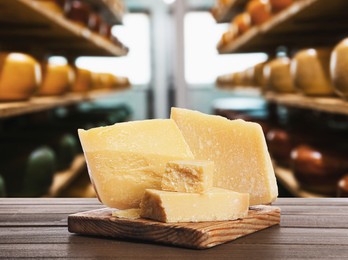 Delicious parmesan cheese on wooden table in warehouse 