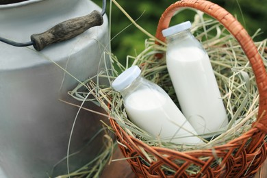 Photo of Tasty fresh milk in wicker basket outdoors, closeup