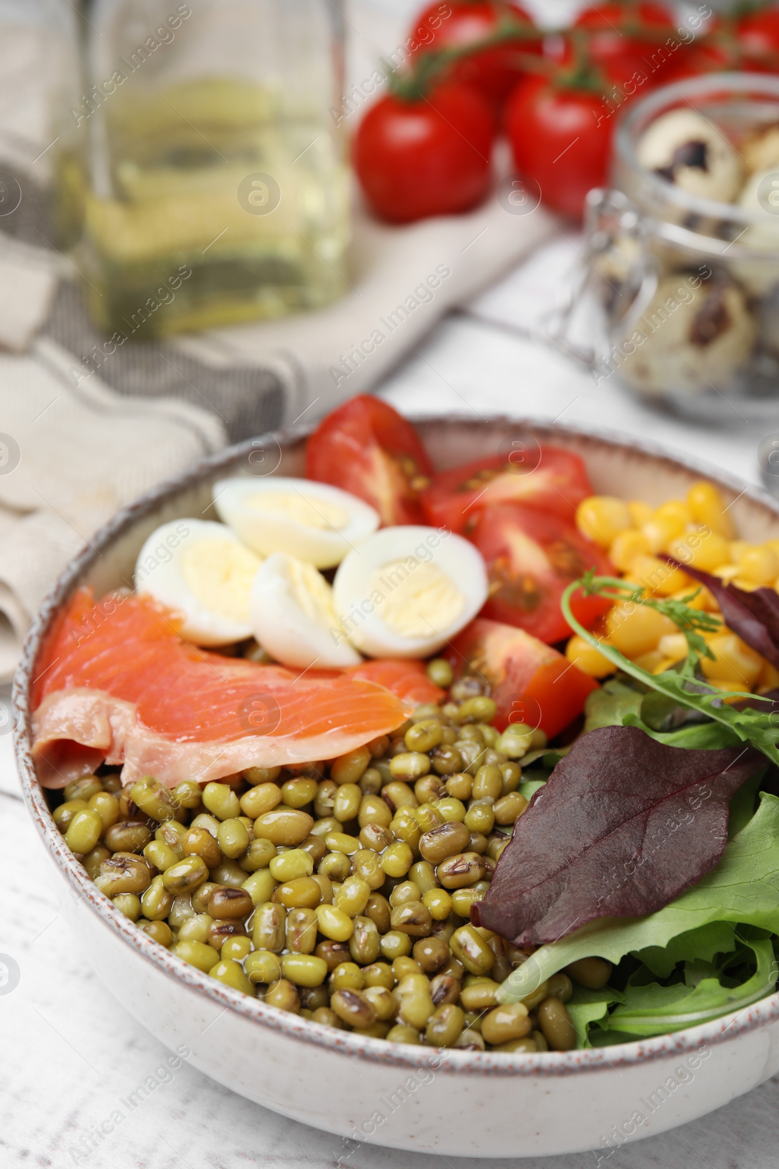 Photo of Bowl of salad with mung beans on white wooden table, closeup