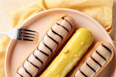 Photo of Different tasty glazed eclairs served on table, top view