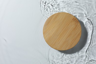 Photo of Presentation of product. Wooden podium in water on white background, top view. Space for text