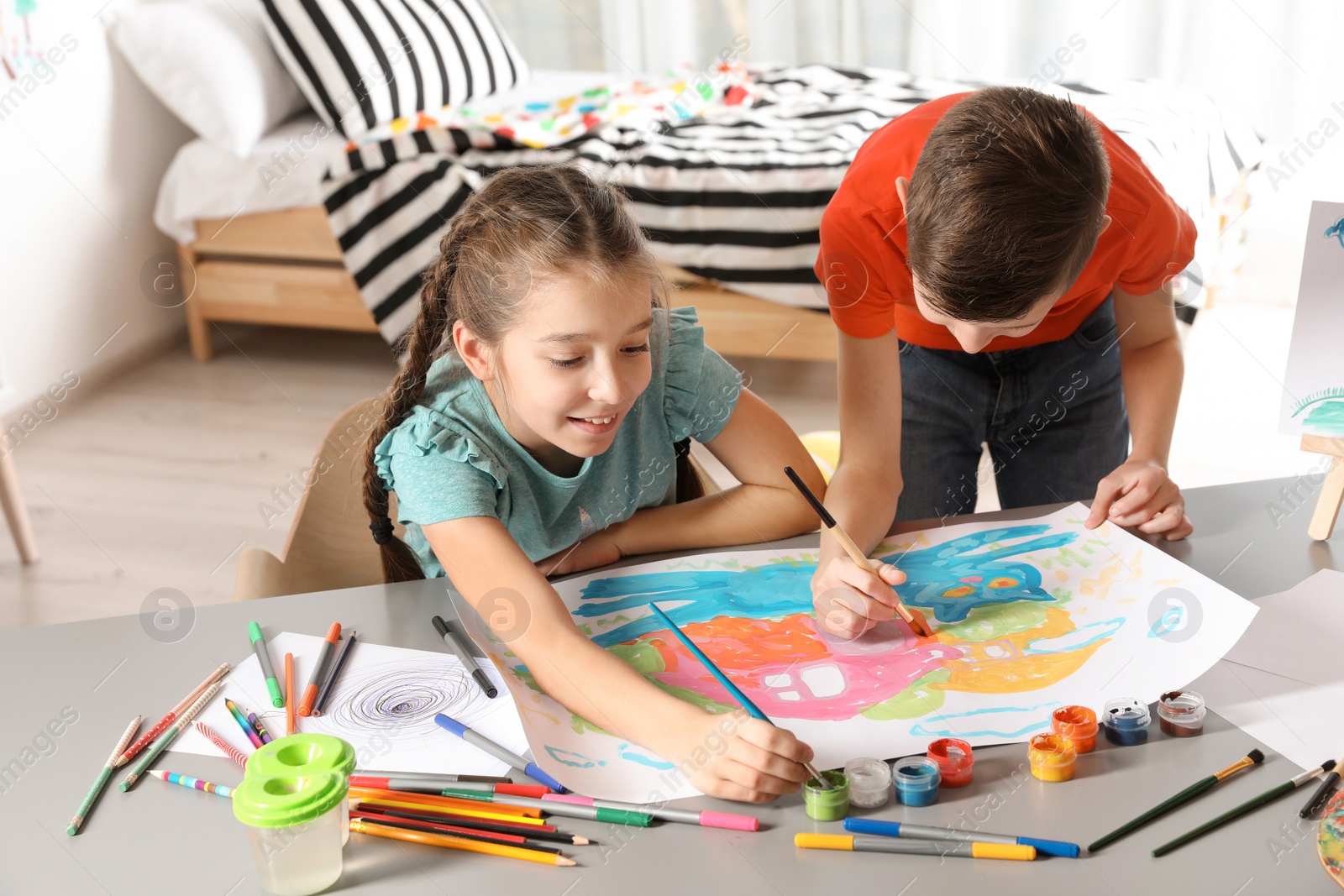 Photo of Little children painting picture at table indoors