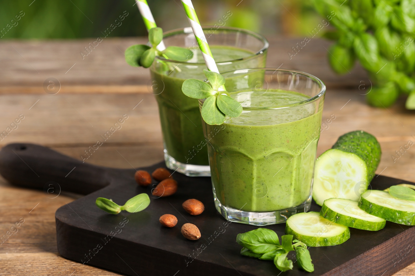 Photo of Glasses of fresh green smoothie and ingredients on wooden table