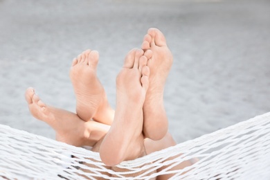 Young couple resting in hammock at seaside. Summer vacation