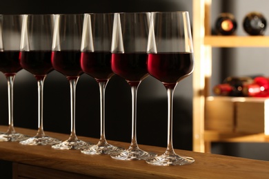 Photo of Glasses of red wine in cellar. Expensive drink