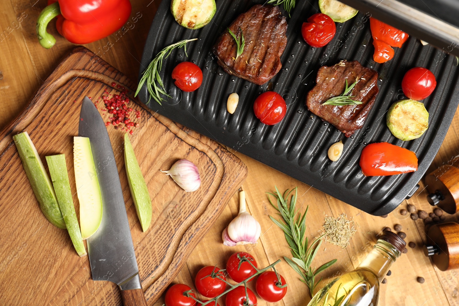 Photo of Flat lay composition with electric grill and different products on wooden table