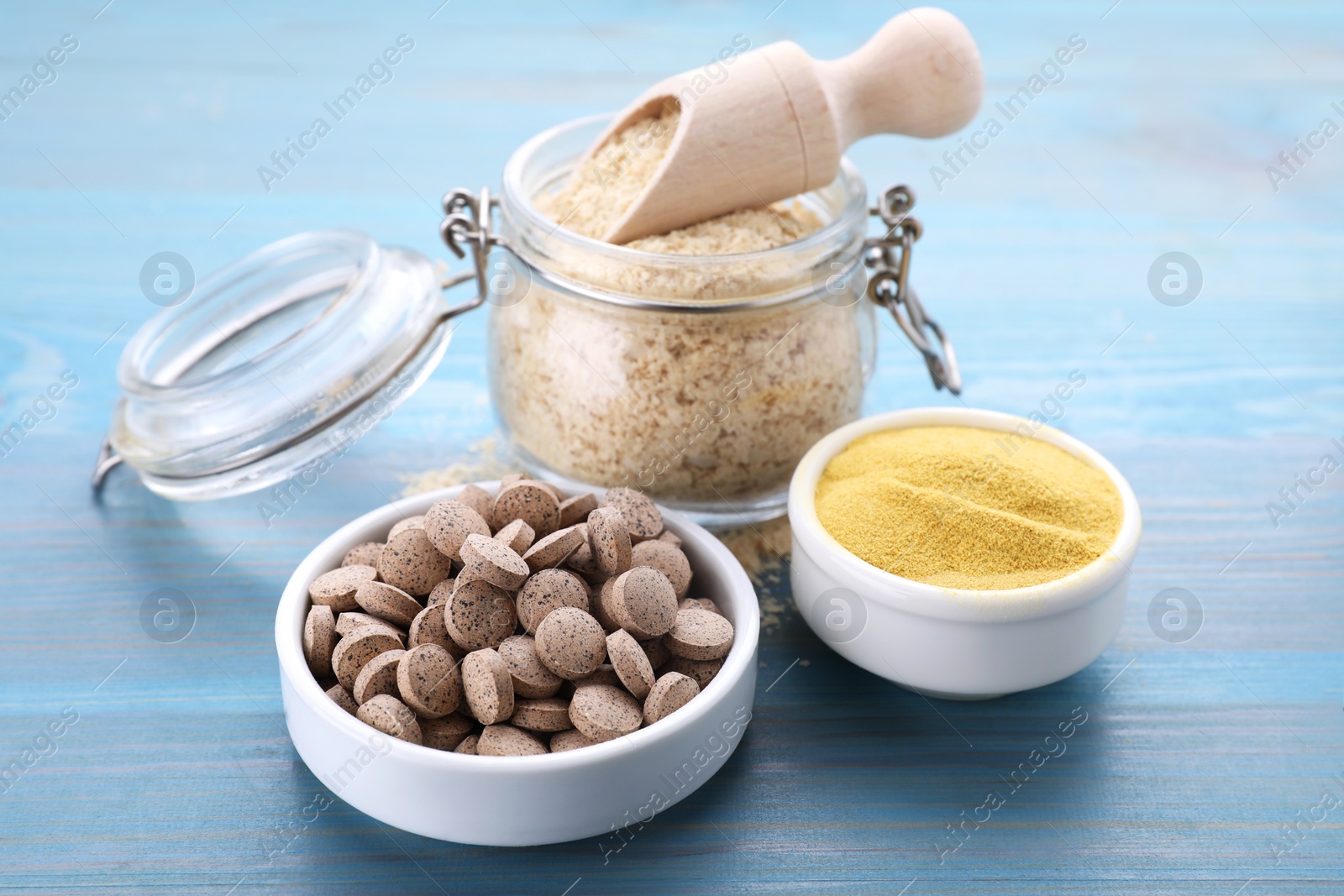 Photo of Different types of brewer's yeast on light blue wooden table