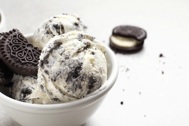 Bowl of chocolate cookies ice cream on table, closeup. Space for text