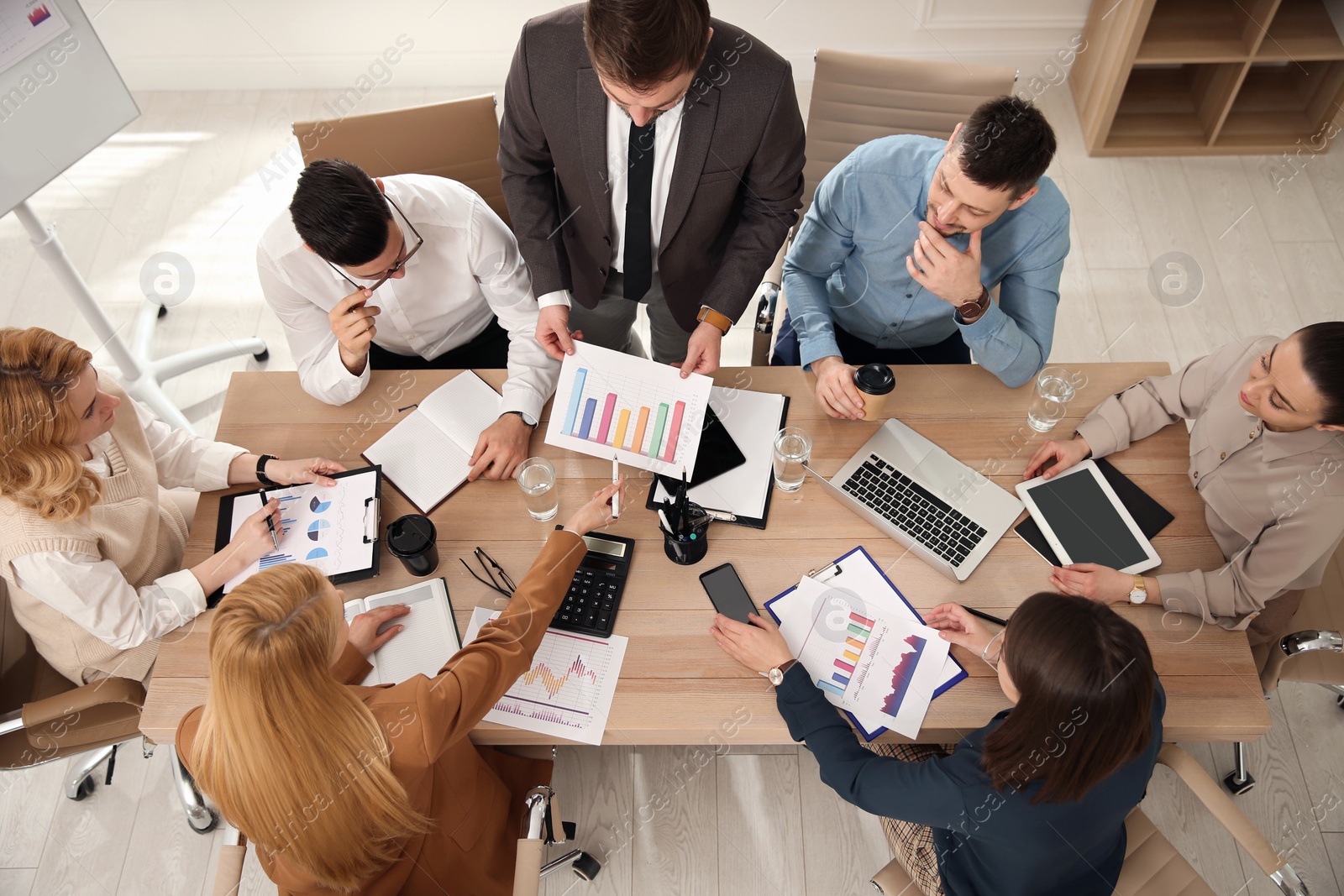 Photo of Businesspeople having meeting in office, above view. Management consulting