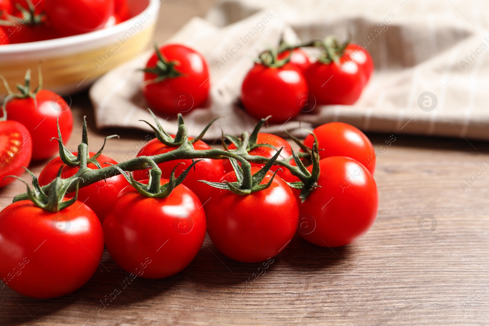 Photo of Branch of cherry tomatoes on wooden background