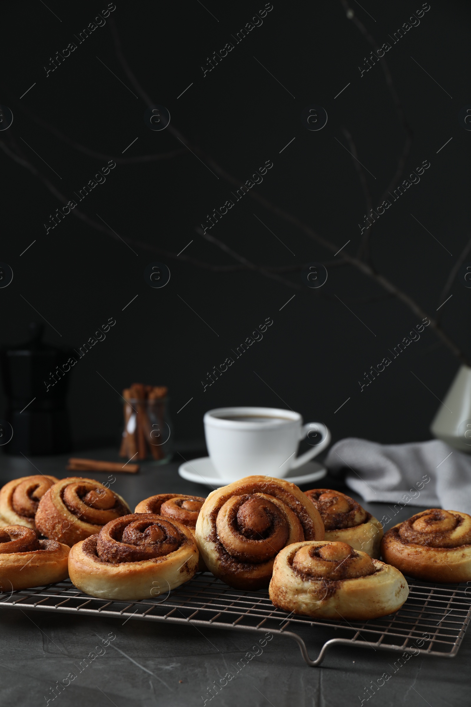 Photo of Tasty cinnamon rolls on black table, space for text